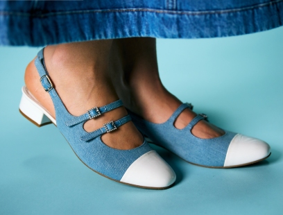 Babyblaue Textil-Slingpumps mit weißer Zehenkappe an Damenfüßen