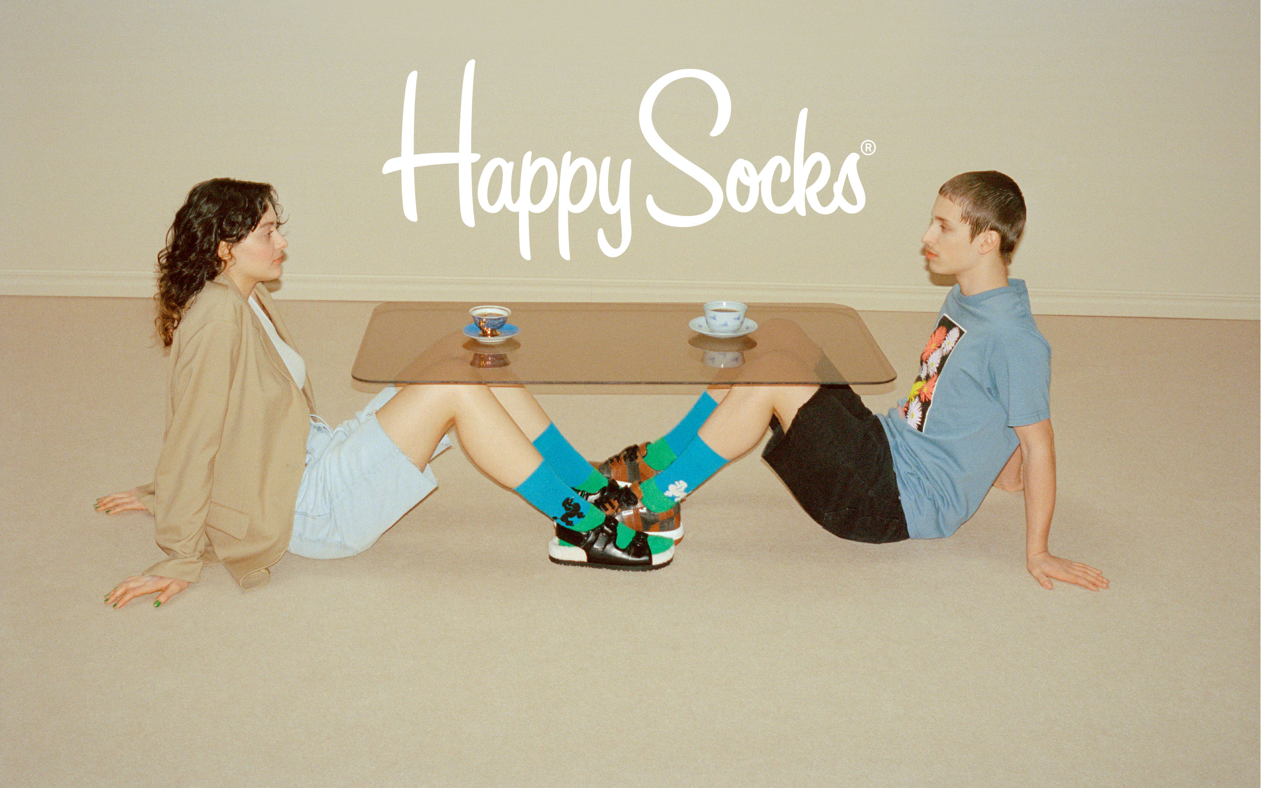 2 Models, die blau-grüne Socken von Happy Socks tragen