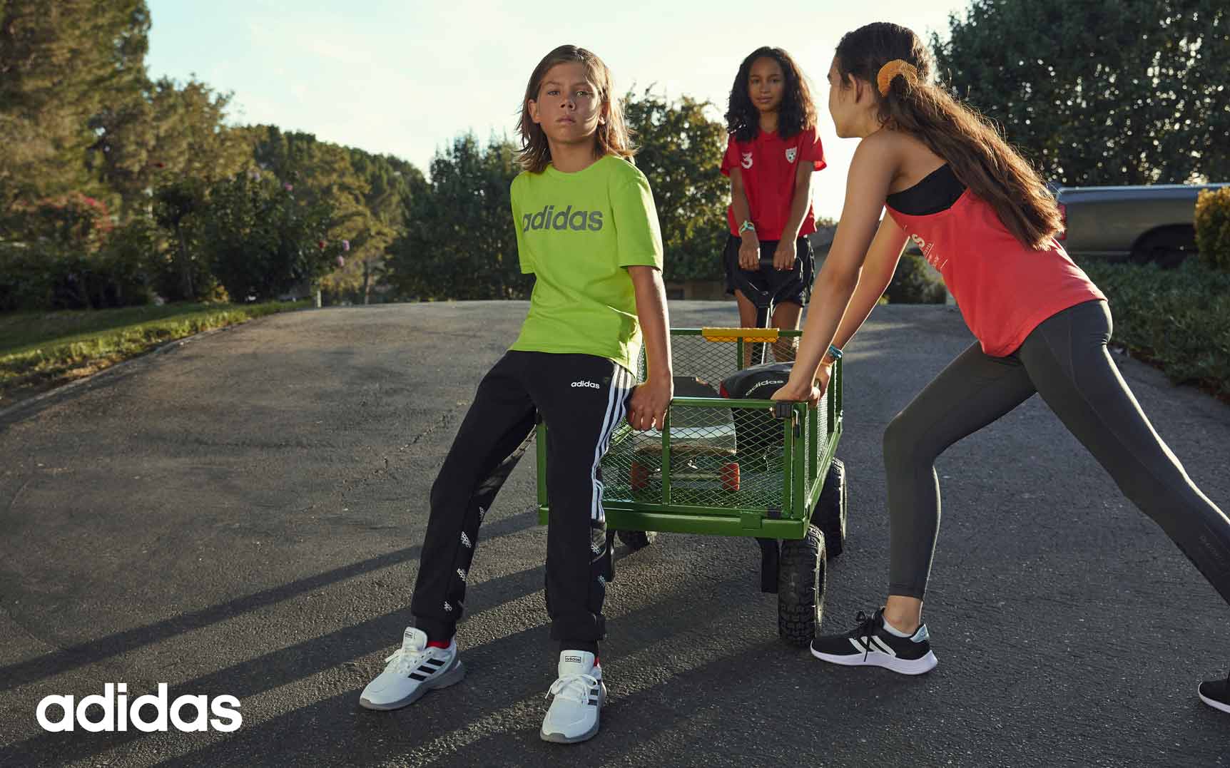 Kinder mit Adidas Sportbekleidung und Adidas Sneaker in weiß und schwarz